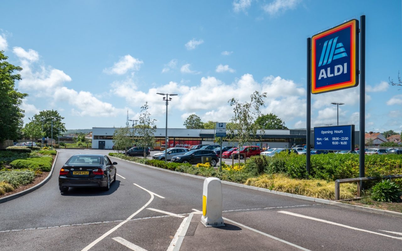 Aldi Supermarket. A car entering the supermarket retailer, Aldi, on a bright day in the East Sussex town of Eastbourne, England.